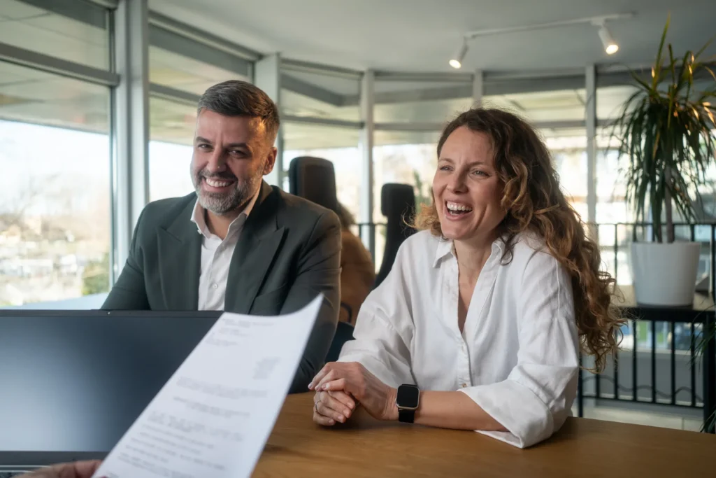 Business owners smiling in a bright office while a lawyer reviews a contract, commercial law Toukley